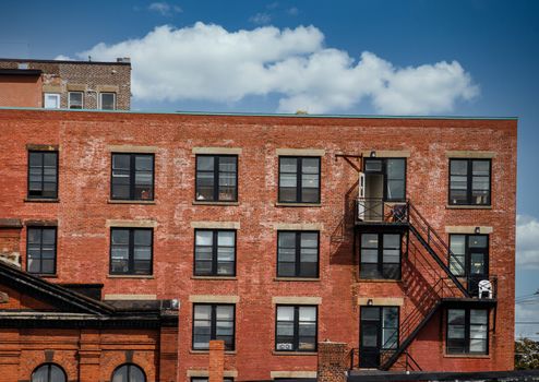 Black iron fire escapes on old brick buildings in Canada