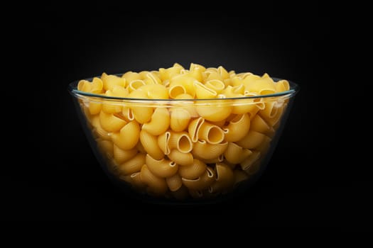 Pasta Pipe Rigate in a glass cup on black background