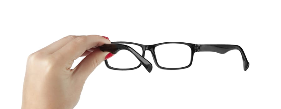 Female hand holding a black-framed glasses isolated on white background