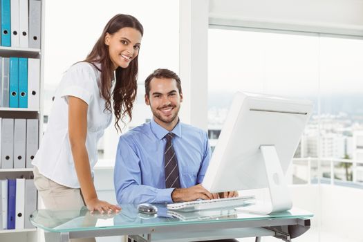 Portrait of young business people using computer in office