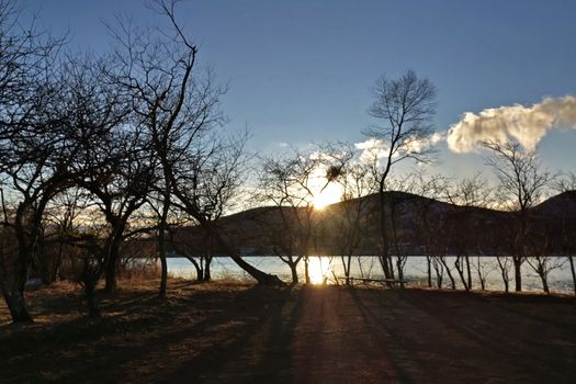 The mountain, tree, lake, blue sky and sun in Japan countryside at sunset