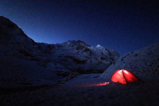 The outdoor red camping tent in Switzerland snow mountain