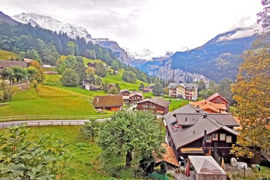 The outdoor countryside house, mountain, green field, footpath with wooden fence in Switzerland village