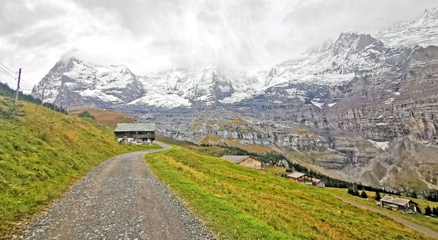 The countryside house, snow mountain, green field, footpath in Switzerland