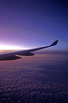 The plane, aeroplane wing, clouds,  gradient sky from aerial view
