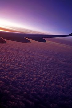 The plane, aeroplane wing, clouds,  gradient sky from aerial view
