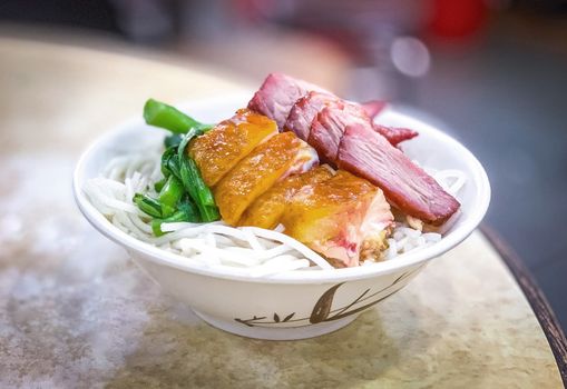 The Chinese food chicken pork and vegetable noodles on the table