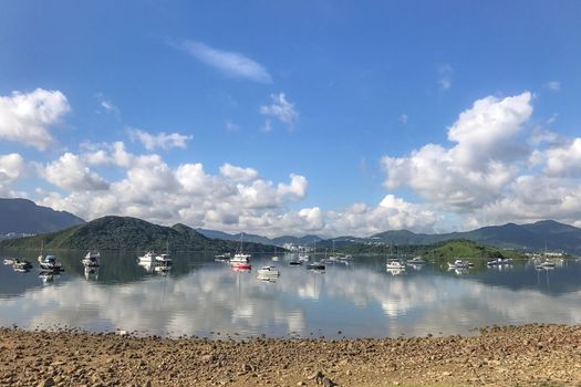 Speedboat, sailboat, yacht, lake and blue sky with water reflection shadow