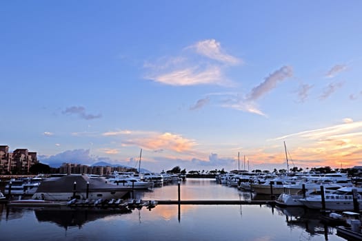 The luxury yacht, pier; building, cloudscape,, gradient sky at sunset