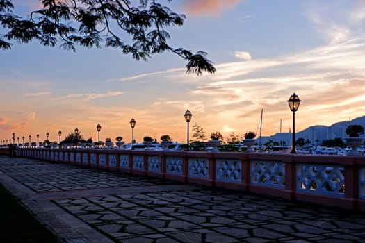 The luxury yacht, footpath, fence,  silhouette of tree and gradient sky at sunset