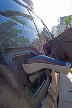 The close up of recharging cable and electric car 