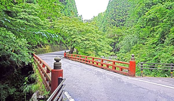 The Japan traditiaonal red bridge and road in the countryside