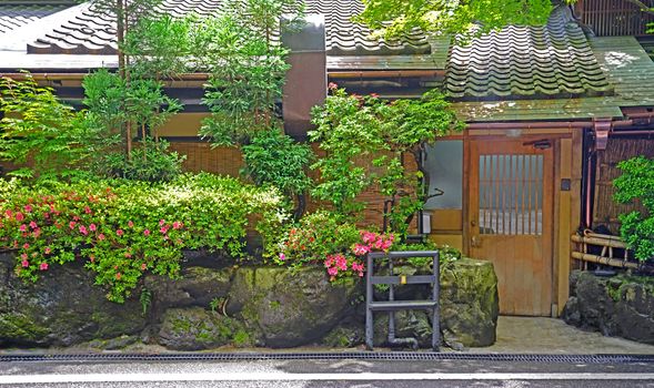 The outdoor footpath, green plants and traditional house in the Japanese zen garden