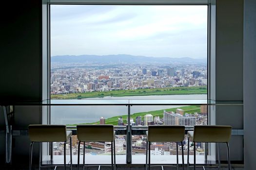 The Japan Osaka aerial view from commerical building with silhouette of bar table and chairs