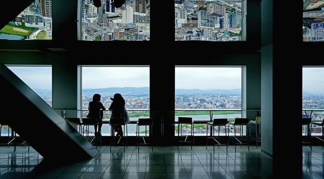 The Japan Osaka aerial view from commerical building with two silhouette women