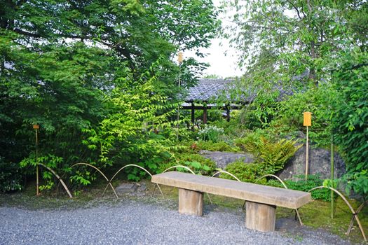 The outdoor bench, green plants, road and pavilion in the Japanese zen garden