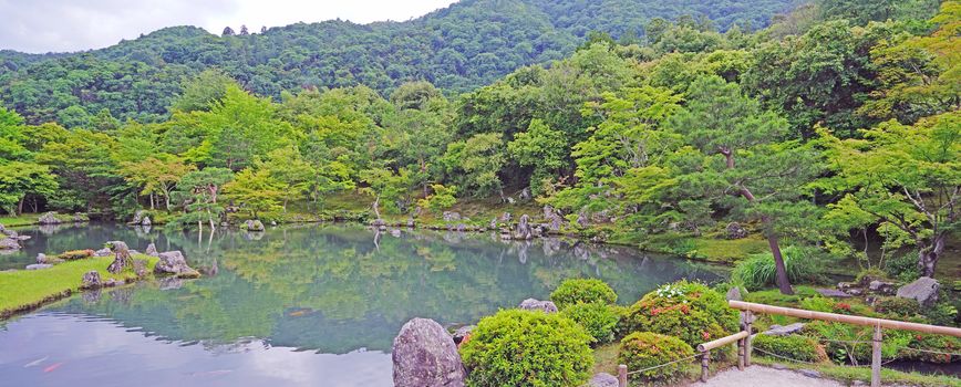 The green plants,  trees, mountain, lake with reflection in the Japan zen garden