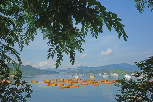 The orange recreational boats on lake, mountains and tree