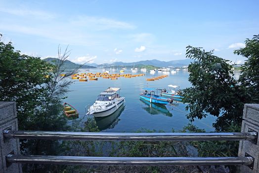 The yacht, fishing and recreational boats on lake, fence and mountains