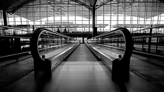 The indoor escalator, window, interior and ceiling of airport archtecture terminal building