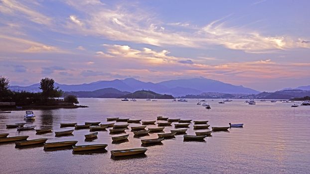 The recreational boats, yachts, sailboats, mountains, bay and beautiful sky at sunset
