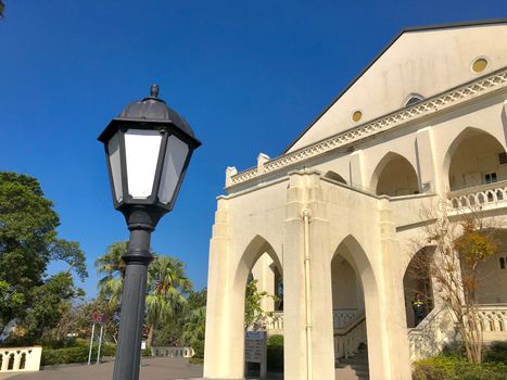 The exterior design of small white christian church with outdoor street lamp