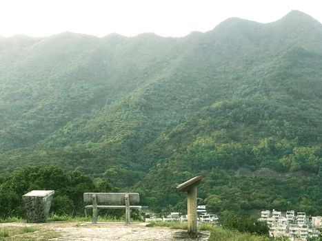 The tree, outdoor chair with village and green mountain background