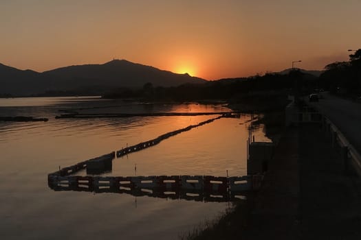 The horizontal silhouette of mountain and ocean at sunset