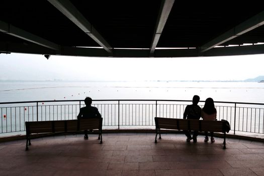 The silhouette of couple, man and the wooden bench