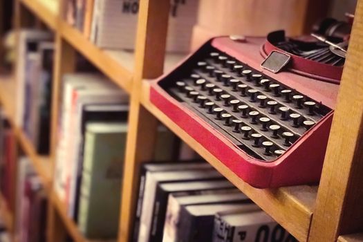 The black and Red vintage metal keyboard machine in the bookshelf