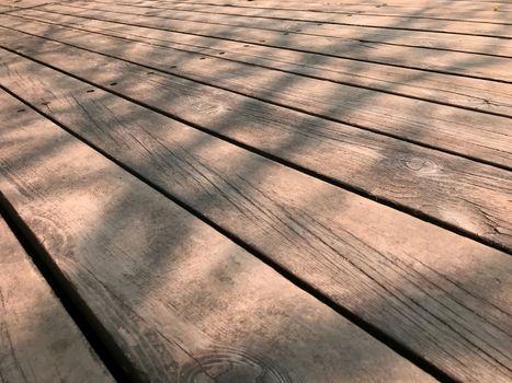 Brown wooden stage floor with woodgrain detail with tree shadow
