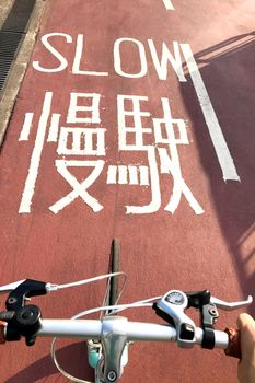 the head of mint green bicycle on the red road with the word slow on the lane