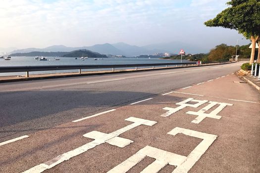 Chinese word Bus stop on the road with ocean, mountain and sky