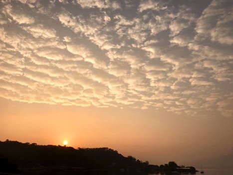 High cumulus cloud, orange sky and the sun at sunset