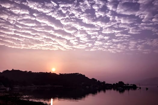 High cumulus cloud, gradient sky and lake at sunrise