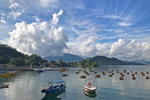The mountain, blue sky, boats, yacht and sailboats near the park