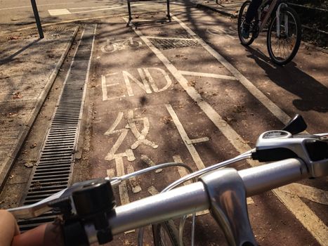 head of bike, bicycle lane with word END on the road