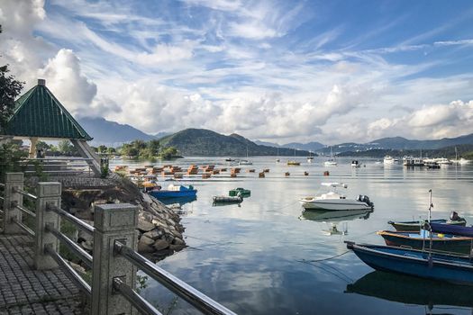 The mountain, blue sky, boats, yacht and sailboats on the lake