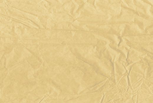 The light brown blank crumpled and grungy textured paper background