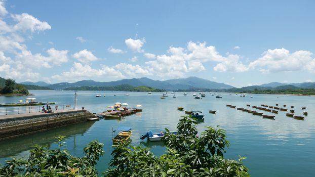 Recreational Boat, lake,pier, mountain and the blue sky