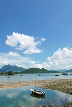 Vertical  recreational fishing Boat, lake, white cloud and the blue sky