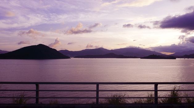 mountain, footpath fence and the sea at sunset