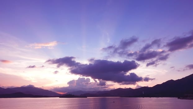 mountain, dramatic sky, boat on the sea at sunset