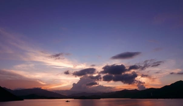 mountain, dramatic sky, boat on the sea at sunset