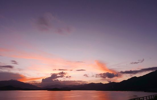 mountain, footpath fence and the sea at sunset