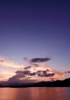 Vertical mountain, cloudscape, dramatic sky and the ocean at sunset