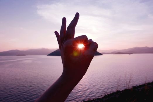 The sunlight is from human hand with mountain and the sea