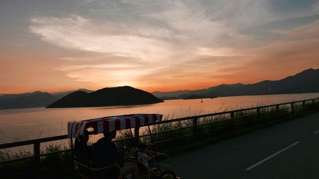 Four wheels bicycle, mountain and sea with gradient sunset