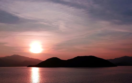 Sun, mountain, ocean and water wave at sunset