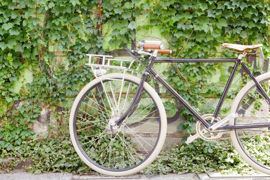 Black old retro bicycle with leather seat with wall